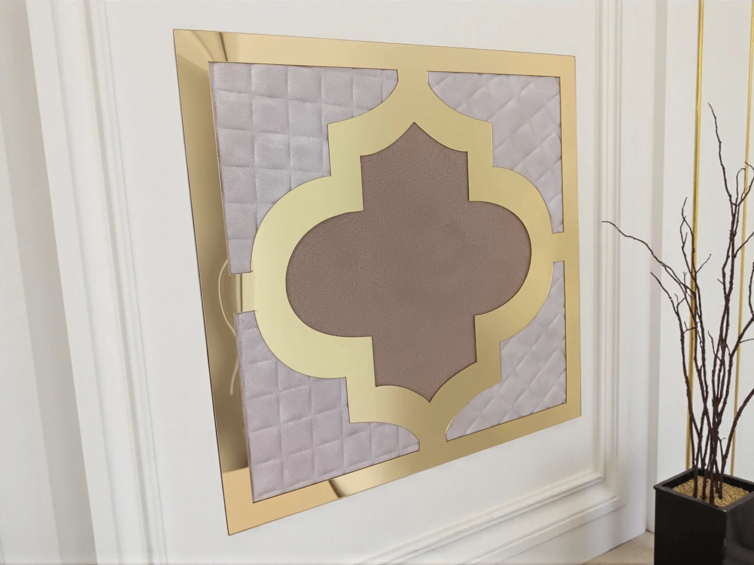 Décoration murale moderne en cuir beige avec cadre doré et éléments géométriques, plante en pot