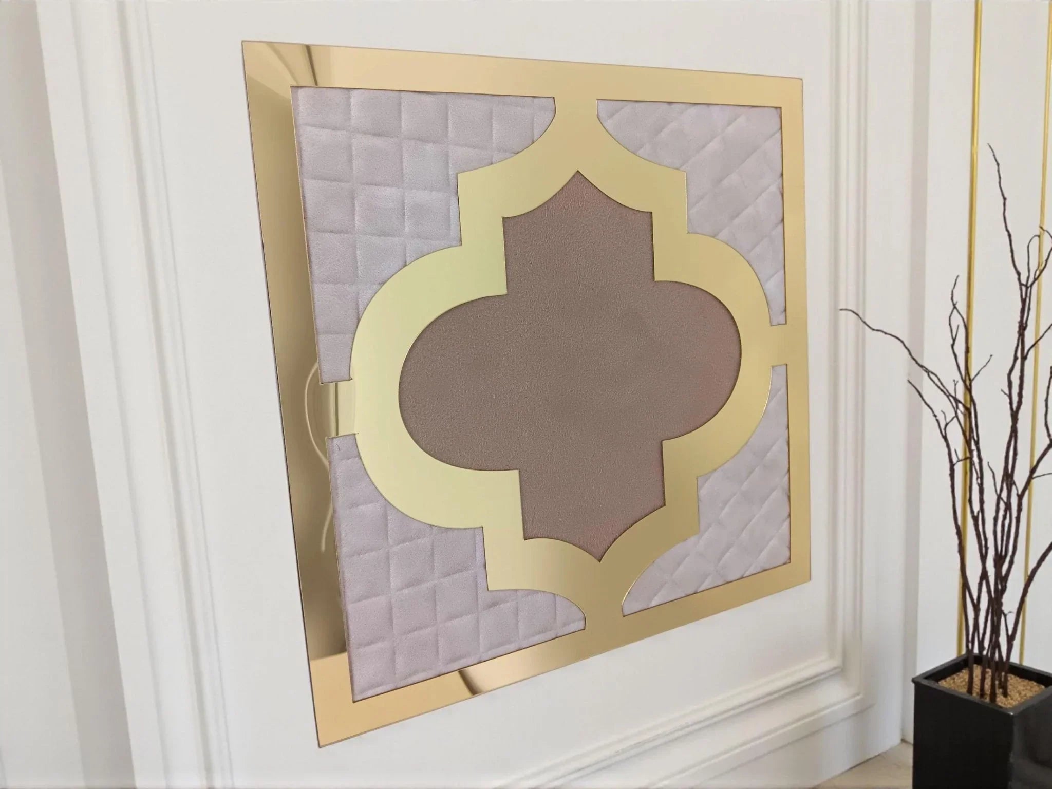 Miroir décoratif doré effet matelassé beige style oriental carré accroché sur mur blanc